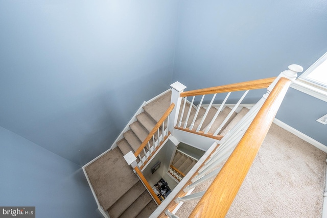 stairs featuring carpet flooring and baseboards