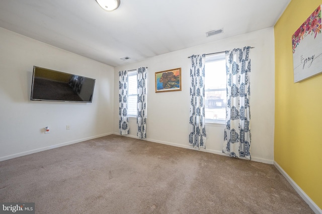 carpeted empty room with baseboards and visible vents