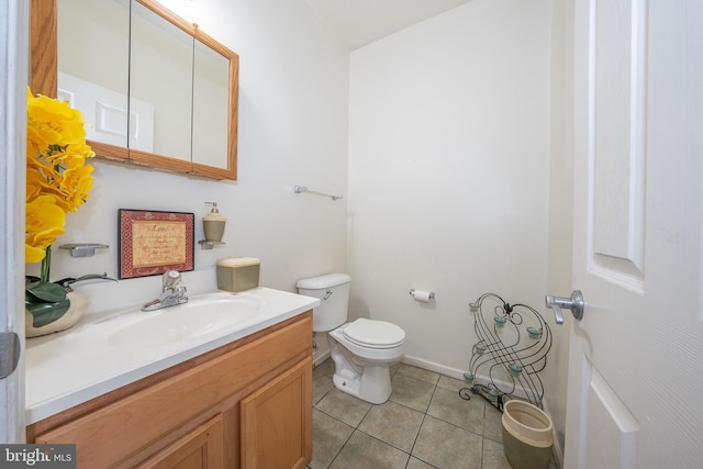 half bath with tile patterned flooring, vanity, and toilet