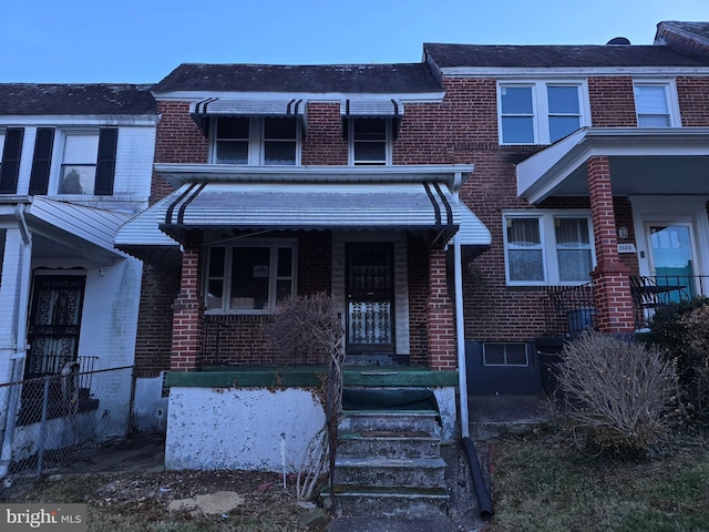 view of property with brick siding and a porch