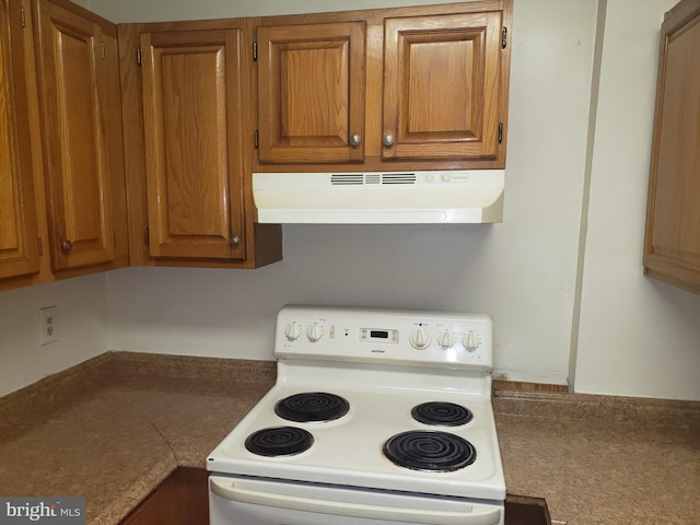 kitchen with brown cabinets, white electric stove, and under cabinet range hood