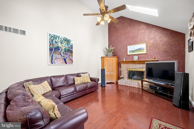 living area featuring a fireplace, visible vents, ceiling fan, wood finished floors, and high vaulted ceiling