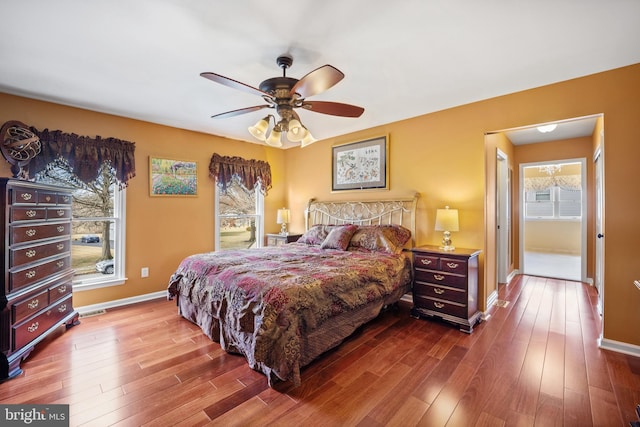 bedroom featuring multiple windows, wood finished floors, and baseboards