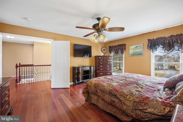 bedroom with dark wood-style floors, ceiling fan, multiple windows, and baseboards