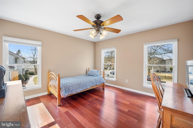 bedroom featuring a ceiling fan, baseboards, and wood finished floors