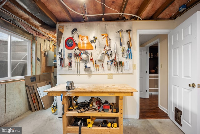 interior space featuring unfinished concrete floors, visible vents, and a workshop area