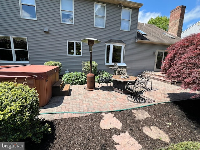 view of patio with a hot tub, a fire pit, and area for grilling