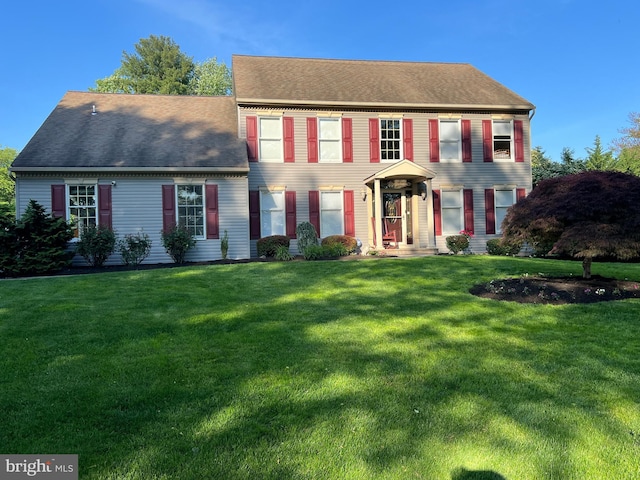 colonial inspired home featuring a front lawn