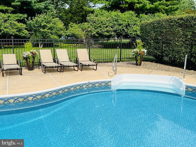 view of swimming pool with a fenced in pool, fence, a lawn, and a patio