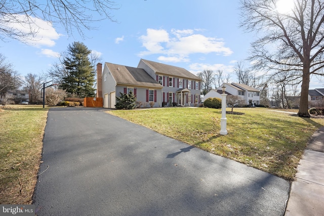 view of front of home featuring a residential view, driveway, and a front lawn