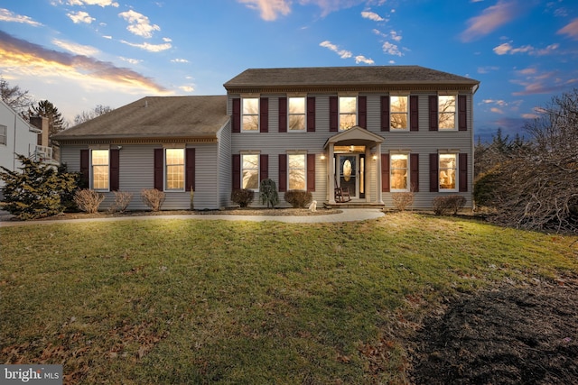 colonial-style house featuring a front lawn