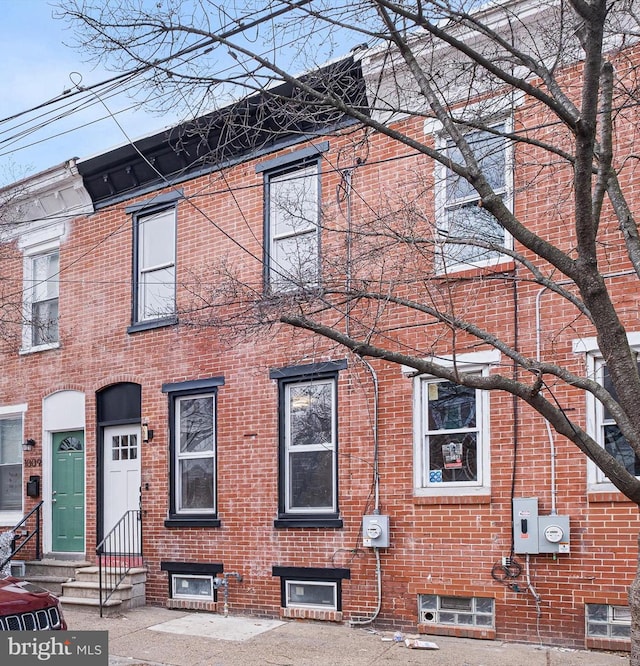 townhome / multi-family property with entry steps and brick siding