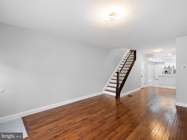 interior space with stairs, baseboards, and wood finished floors