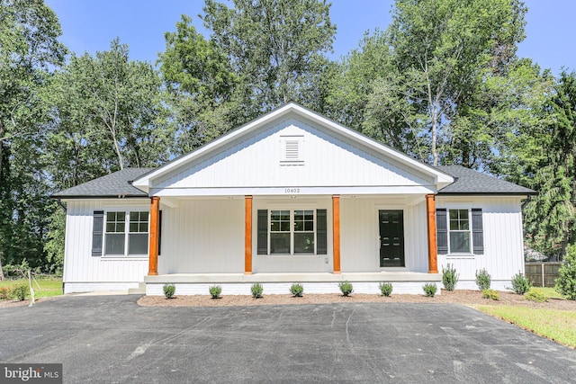 modern farmhouse style home featuring covered porch and a shingled roof