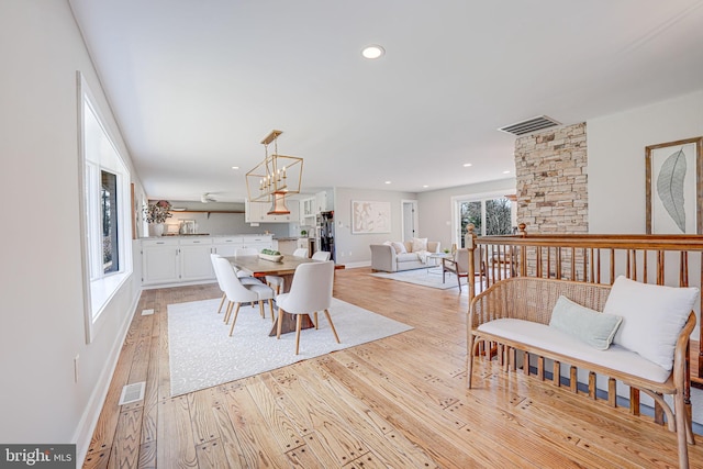 dining room featuring baseboards, light wood finished floors, visible vents, and recessed lighting