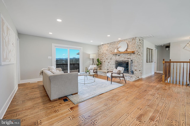 living area featuring light wood finished floors, recessed lighting, a fireplace, and baseboards