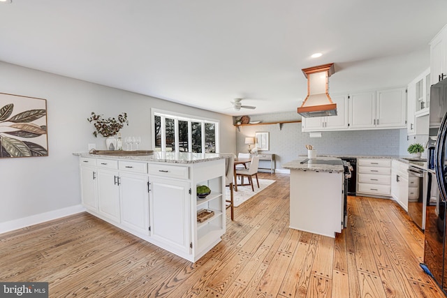 kitchen featuring extractor fan, a peninsula, white cabinetry, open shelves, and light wood finished floors