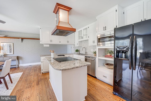 kitchen with a center island, white cabinetry, a sink, ventilation hood, and black appliances