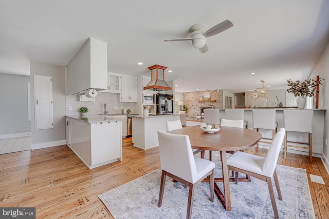 dining space with ceiling fan, light wood finished floors, baseboards, and recessed lighting