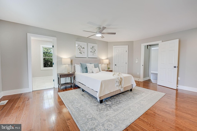 bedroom with light wood finished floors, visible vents, baseboards, a ceiling fan, and a closet