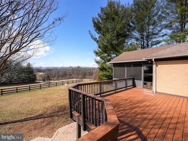 deck featuring a sunroom, fence, and a lawn