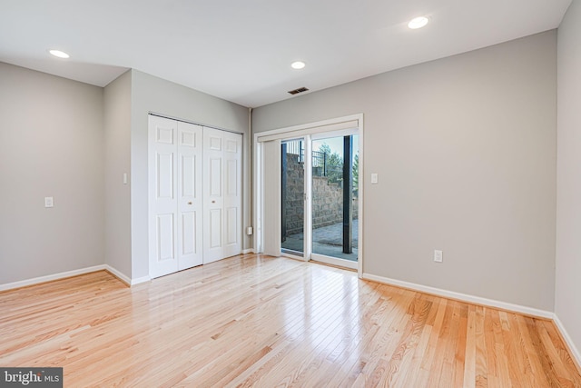 unfurnished bedroom featuring light wood finished floors, access to outside, visible vents, and baseboards