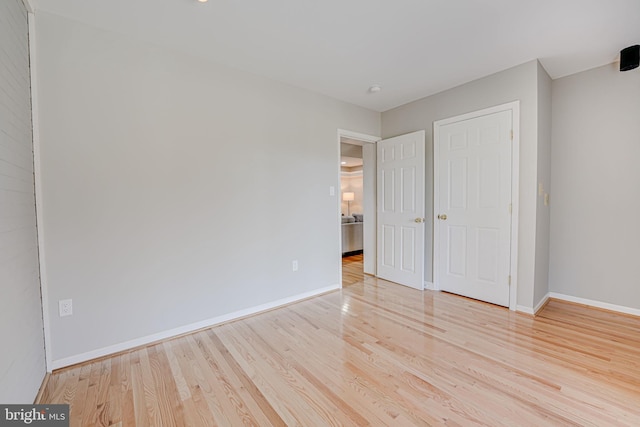 unfurnished bedroom with baseboards and wood finished floors