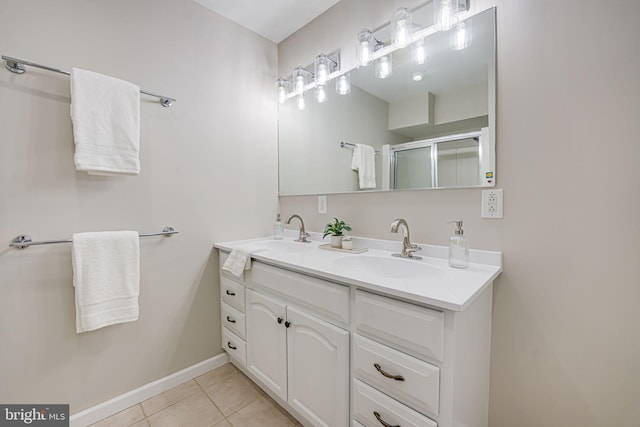 full bathroom featuring double vanity, a sink, a shower stall, and tile patterned floors