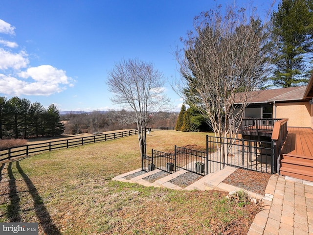 view of yard with a gate, a rural view, fence, and a wooden deck