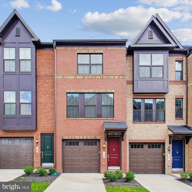 townhome / multi-family property with driveway, brick siding, and an attached garage