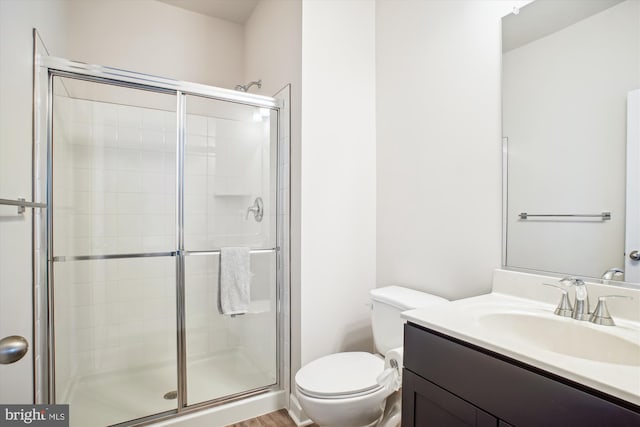 full bath featuring toilet, a stall shower, and vanity