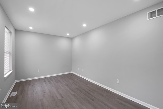 empty room with baseboards, visible vents, wood finished floors, and recessed lighting