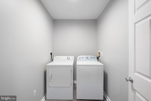 washroom with laundry area, baseboards, and washing machine and clothes dryer