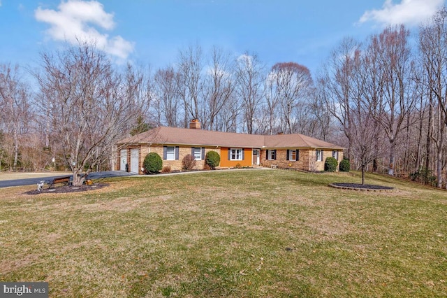 ranch-style home featuring a garage, a chimney, a front lawn, and aphalt driveway