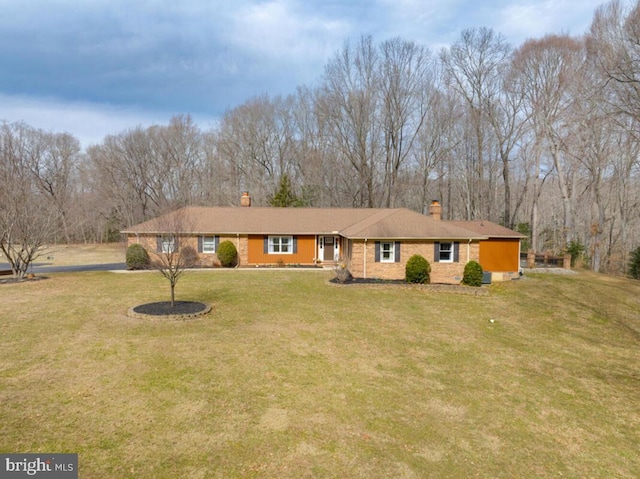 single story home with brick siding, a chimney, and a front yard