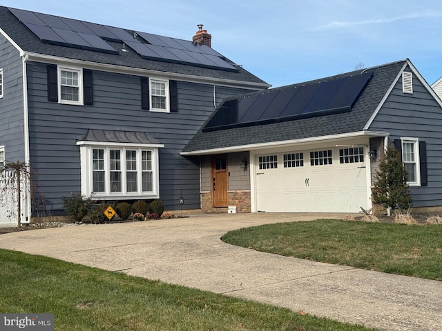 view of front of property with a garage, roof mounted solar panels, a chimney, and roof with shingles