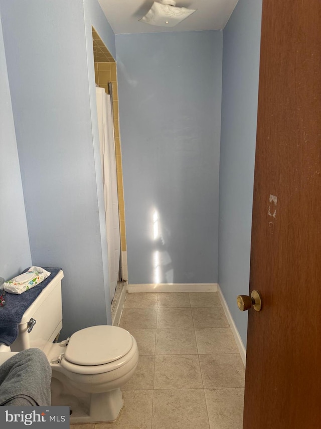 full bath with baseboards, curtained shower, toilet, and tile patterned floors