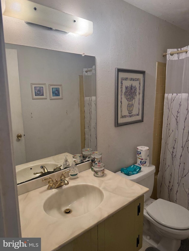 full bathroom featuring toilet, vanity, and a shower with shower curtain