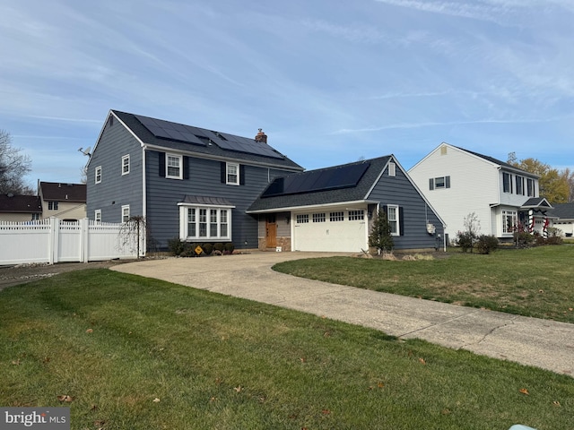 view of front of house featuring driveway, solar panels, an attached garage, fence, and a front lawn