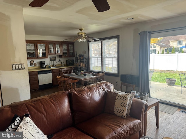 living room with ceiling fan, visible vents, indoor bar, and wood finished floors