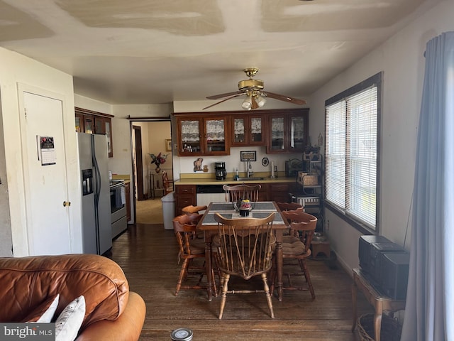 dining area with ceiling fan and dark wood-style flooring