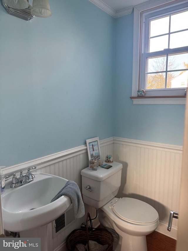 bathroom featuring visible vents, wainscoting, toilet, and crown molding