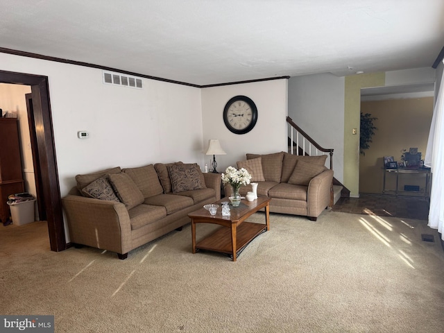 living area featuring ornamental molding, carpet, visible vents, and stairway