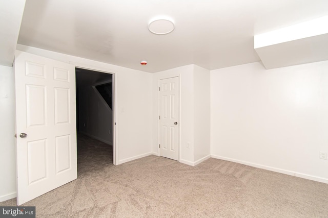 unfurnished bedroom with light colored carpet and baseboards