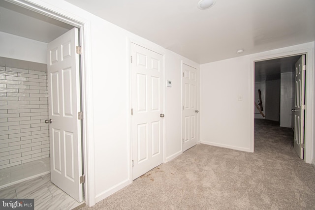 unfurnished bedroom featuring light carpet and baseboards