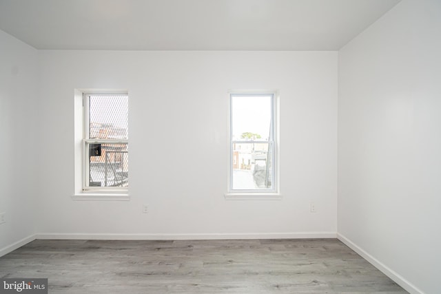 empty room featuring light wood-style flooring and baseboards