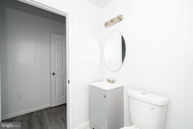 bathroom featuring vanity, wood finished floors, toilet, and baseboards