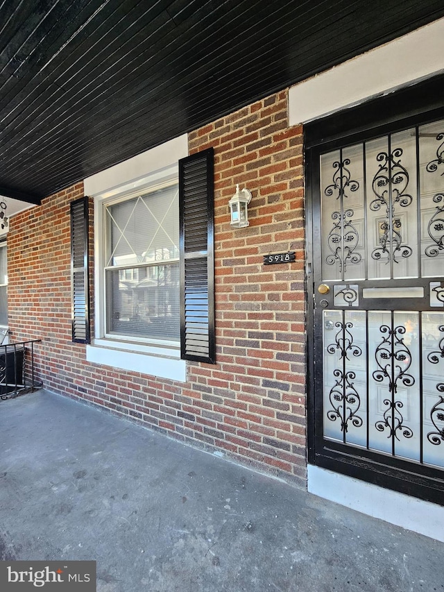 doorway to property with brick siding