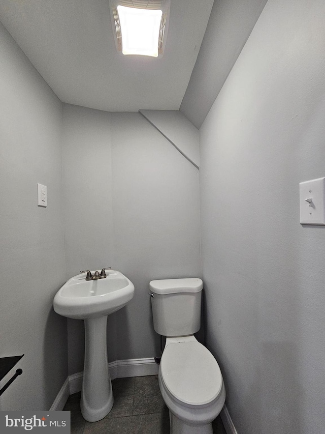 half bathroom with toilet and baseboards