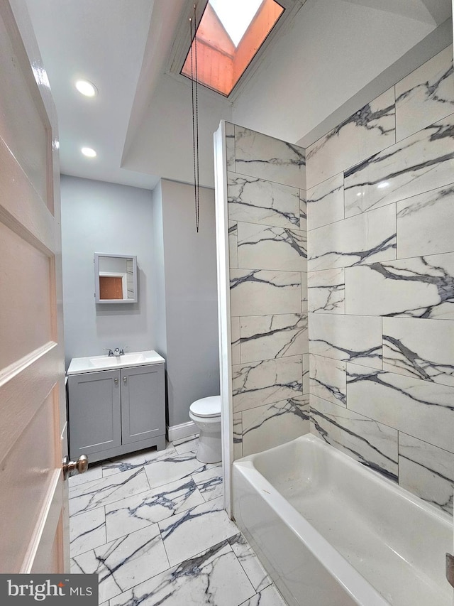 full bathroom featuring a skylight, marble finish floor, recessed lighting, toilet, and vanity